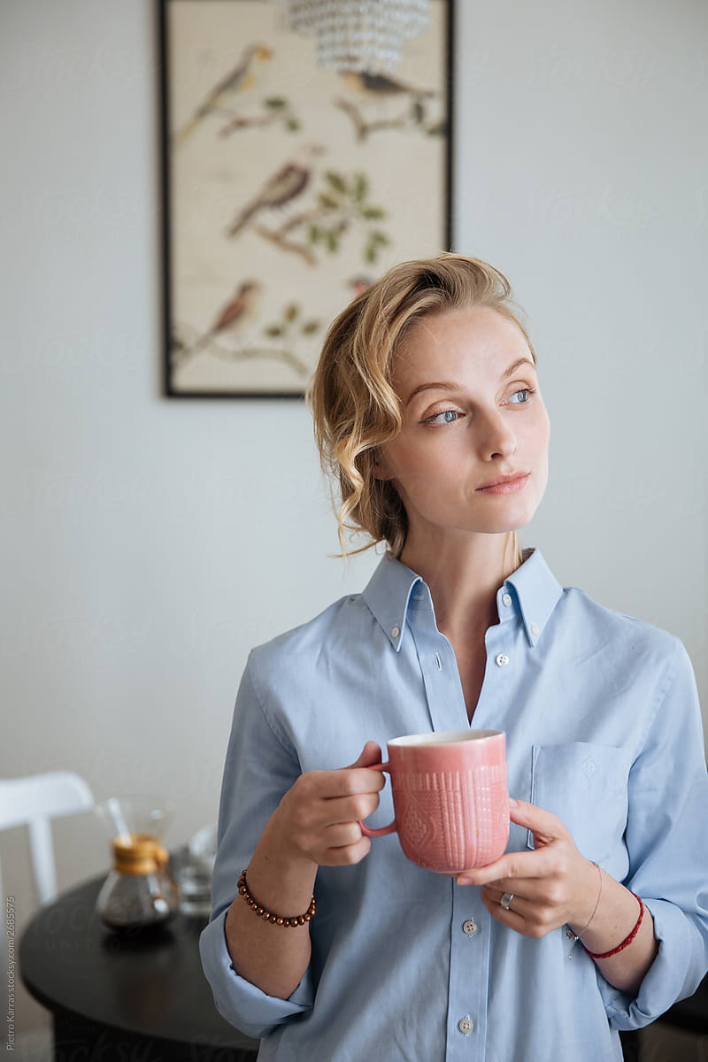 Attractive woman with cup of coffee looking along