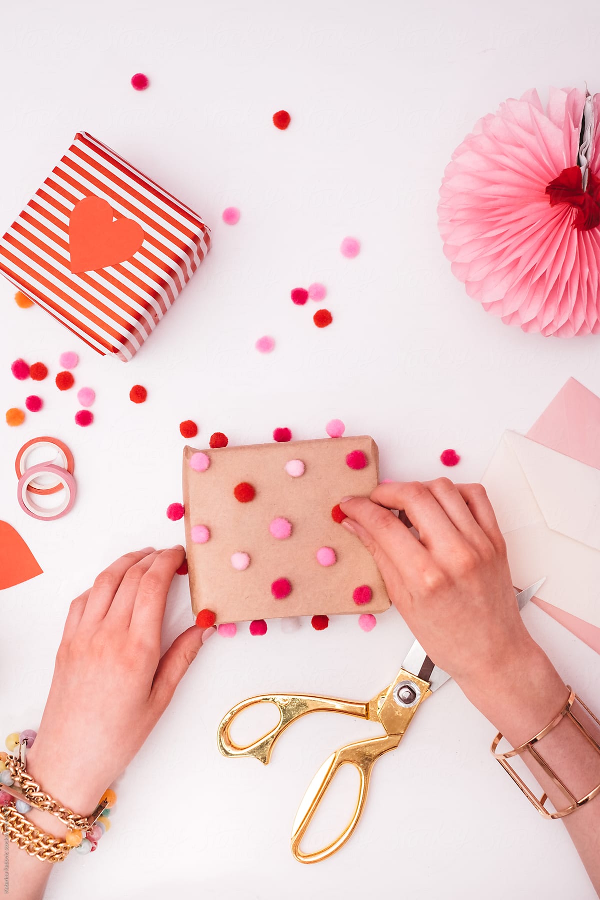 Woman Decorating Valentine\'s Day Gift With Pompons