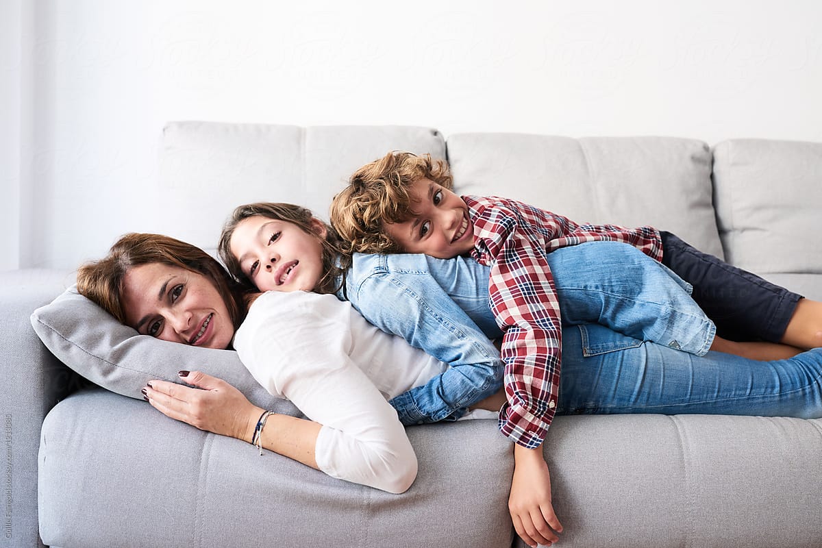 Mother with kids lying all together on sofa