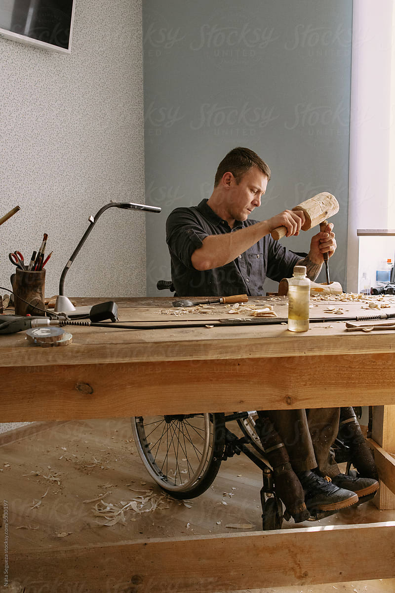 A carpenter in a wheelchair works from home