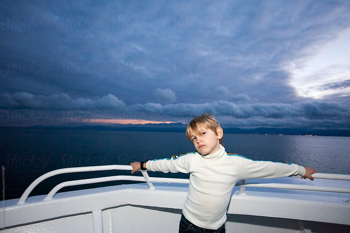 Six year old boy throws attitude on a boat at sunset