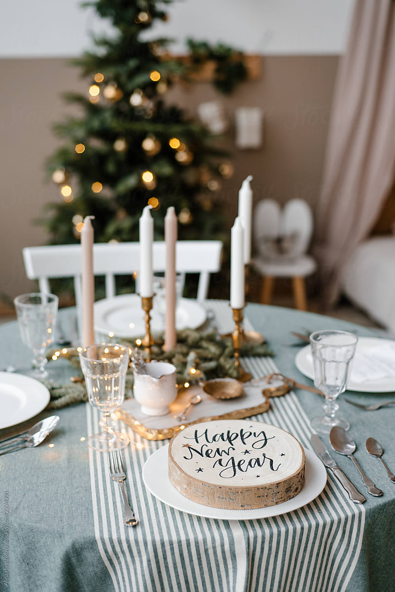 Wood circle with happy New Year inscription on table near fir tree
