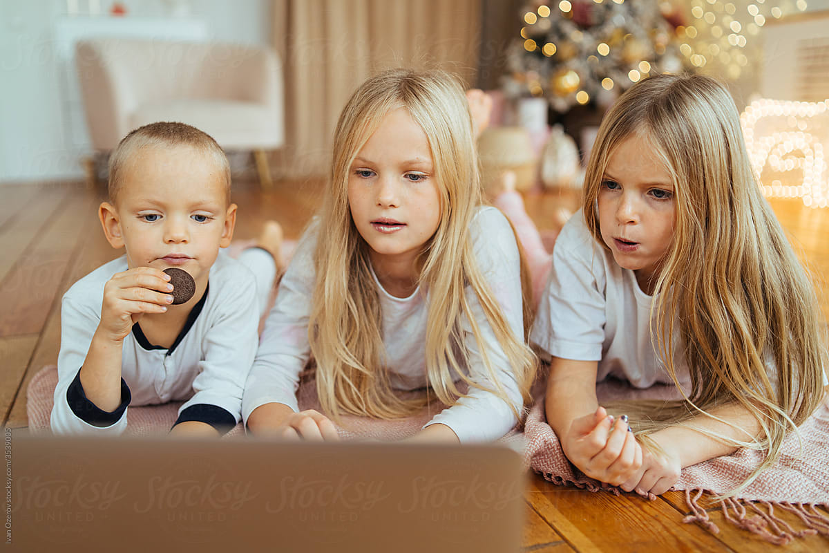 Cute children watching movie on laptop at Christmas