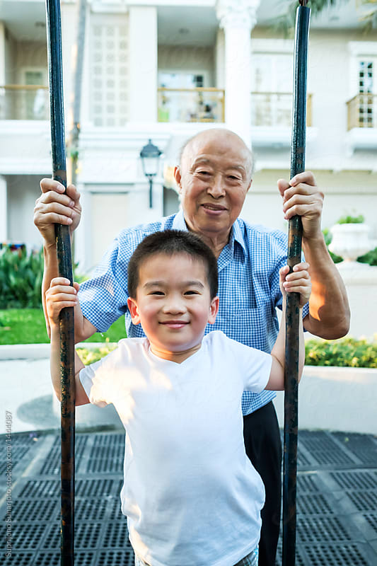 Happy Senior Asian Man With His Grandchild in the Playground