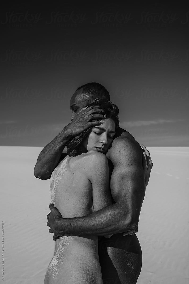 African Man Is Hugging A Woman In The Desert Monochrome/ photo