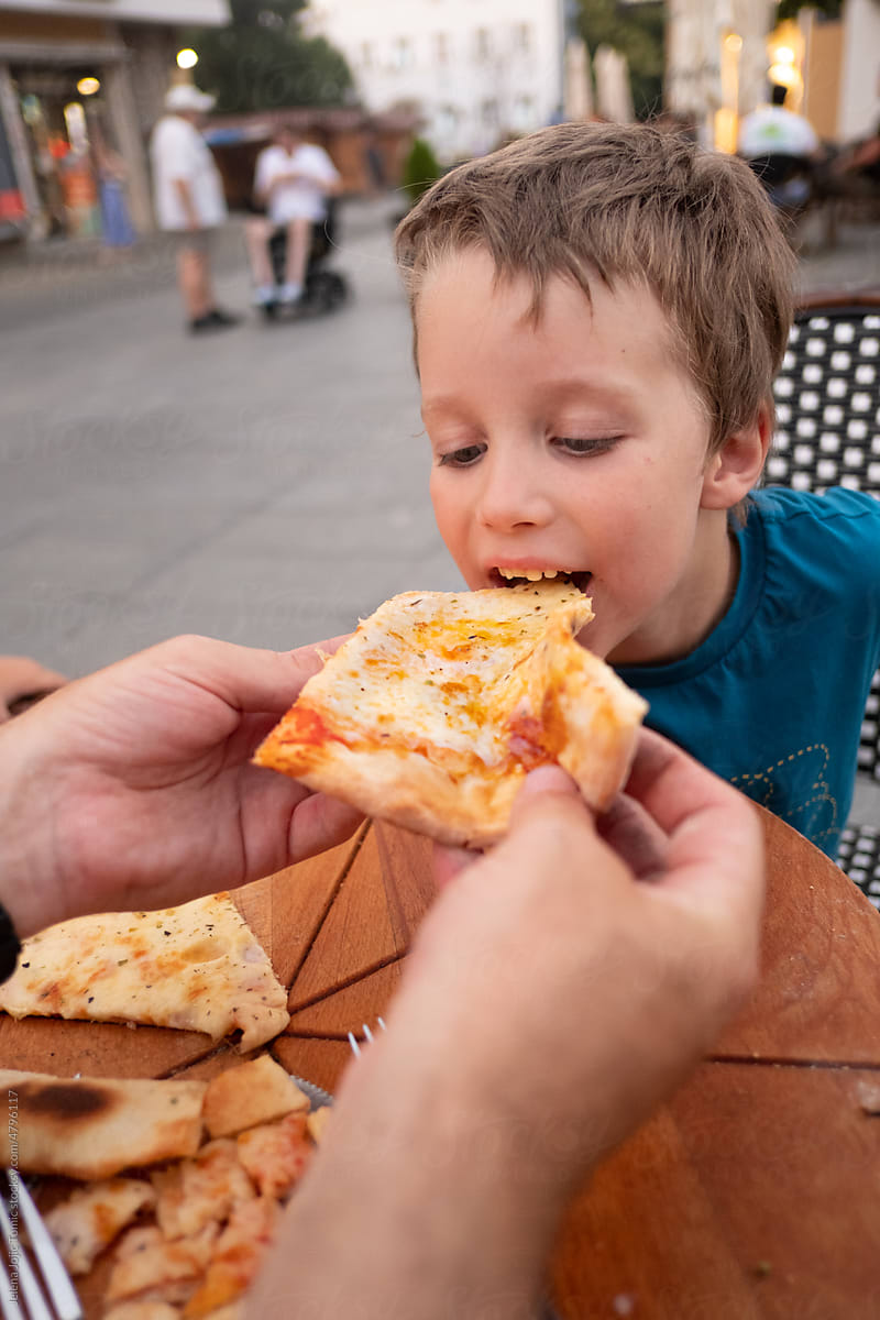 Child eating a pizza slice