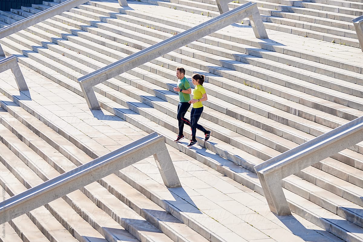 Couple of runners working out on stairs.
