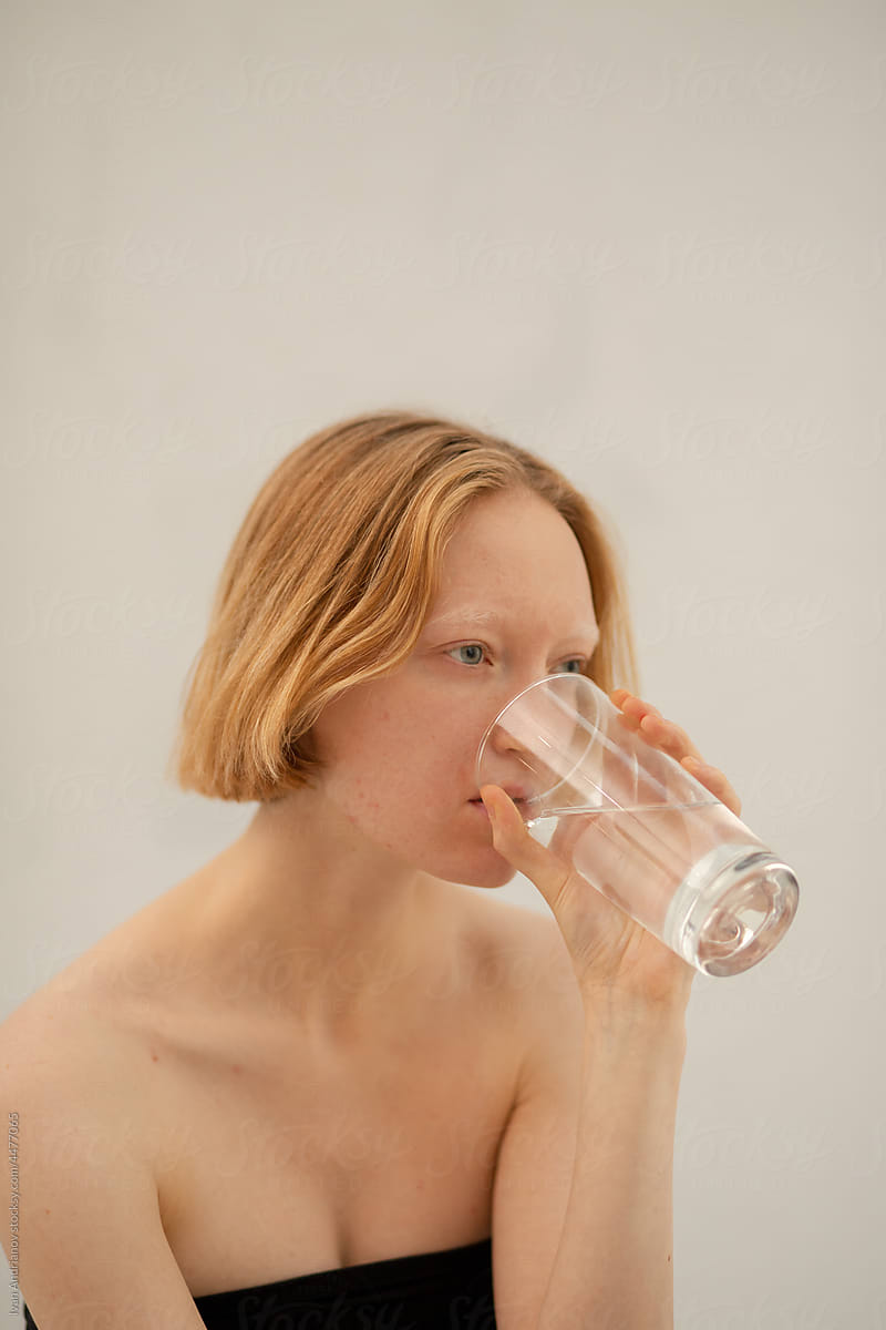 Portrait of young albino woman with transparent glass