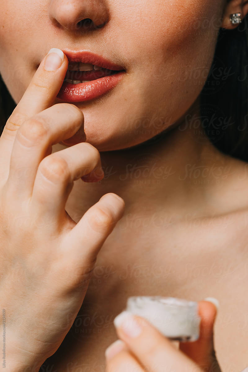 Woman applying balm on lips