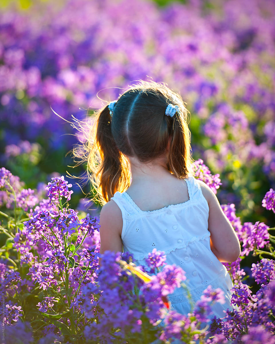 Young girl in white dress, sun kissed, moving through Lavender