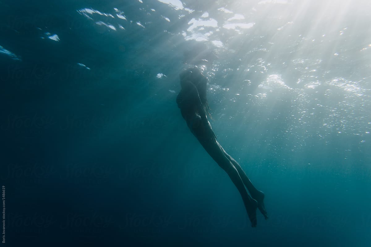 Wide Shot Of A Woman Swimming Underwater