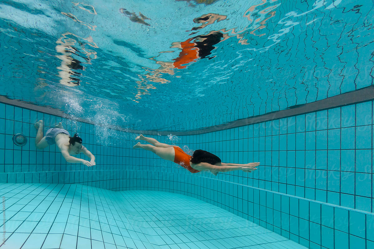 TA Couple Friends Dive Underwater In A Residential Pool In Singapore By Stocksy Contributor