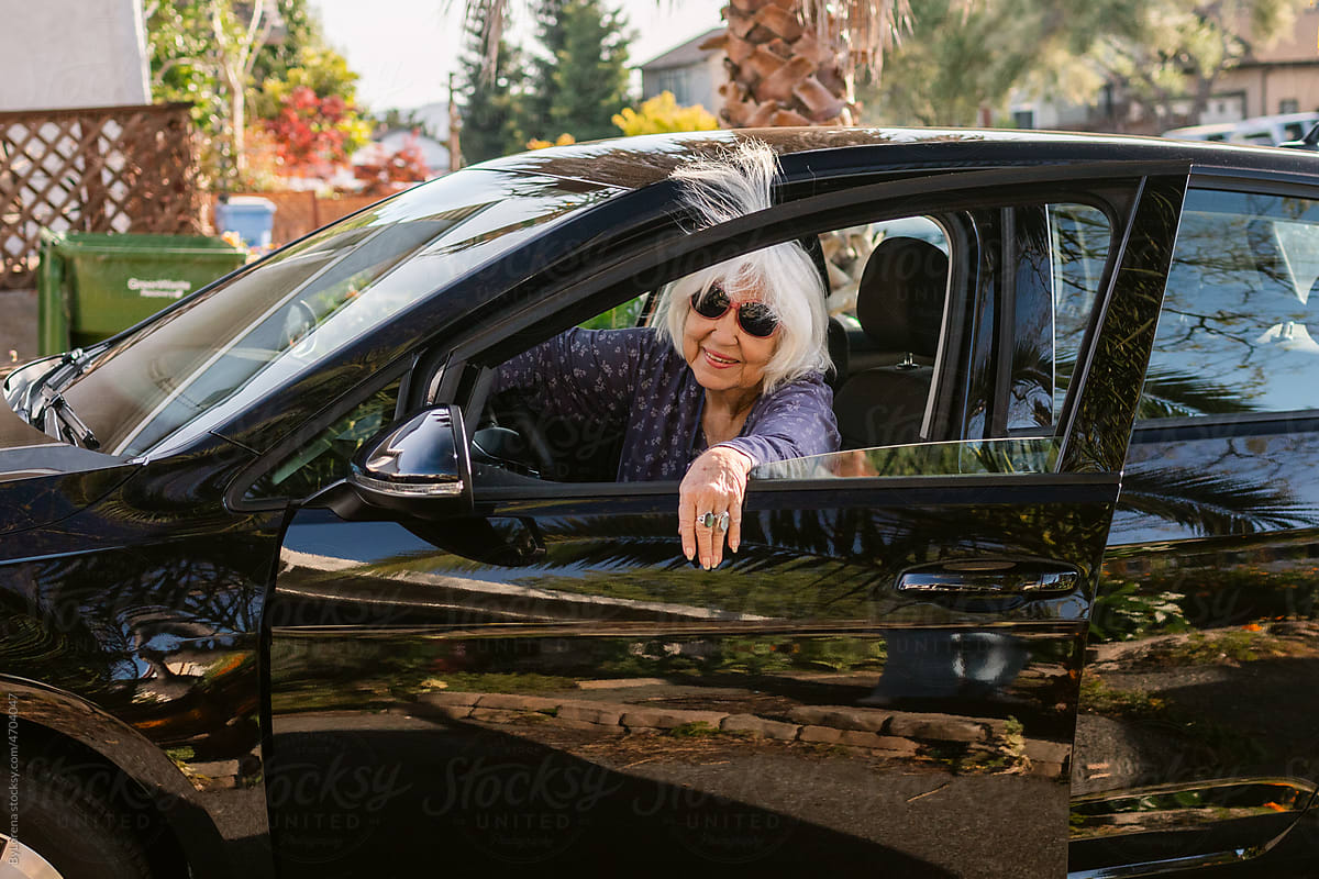 Fun Senior woman getting into her car