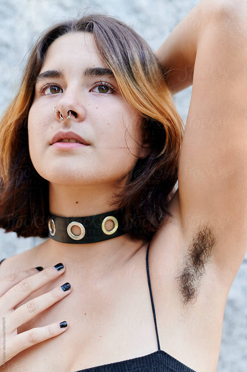 Young person with armpit hair standing outside