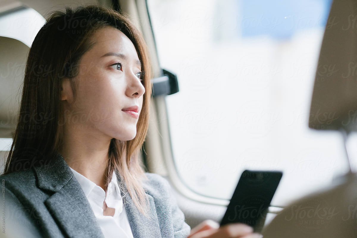 Businesswoman Sitting In Taxi And Using Cell Phone
