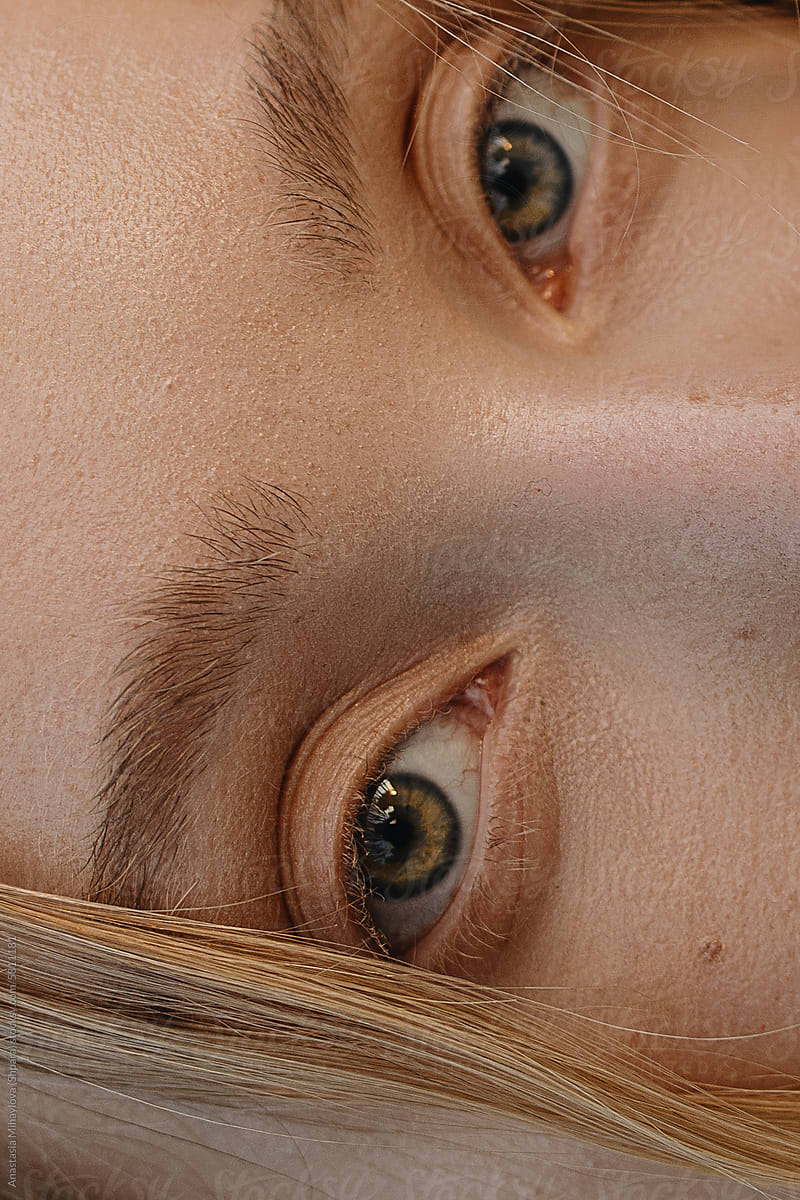 Close Up woman's green eyes with white eyelashes and eyebrows