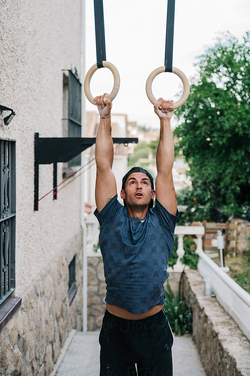 Strong man exercising with gymnastic rings