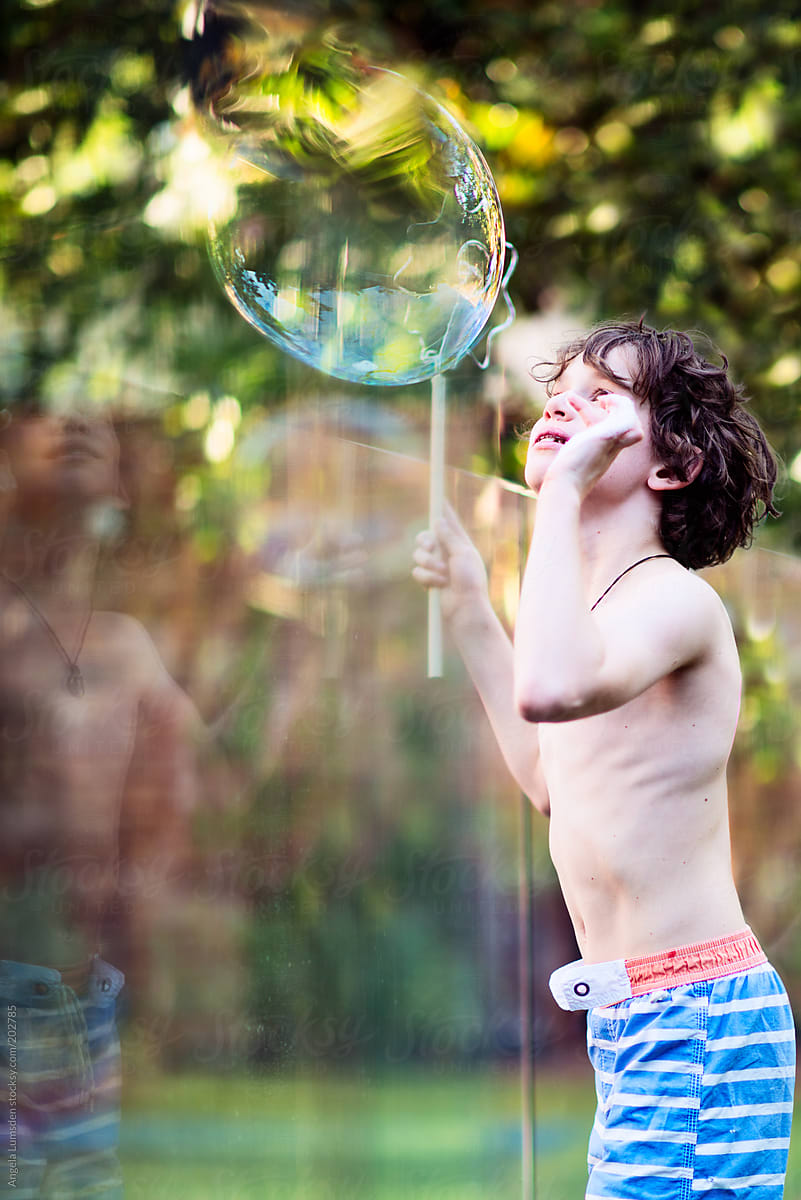 Boy playing with bubbles in a garden in summer