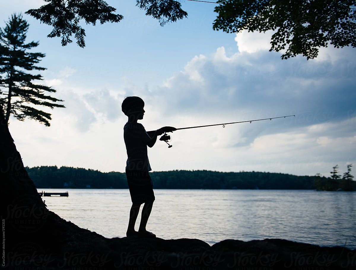 Teenage boys fishing in river at sunset, Washington, USA Stock