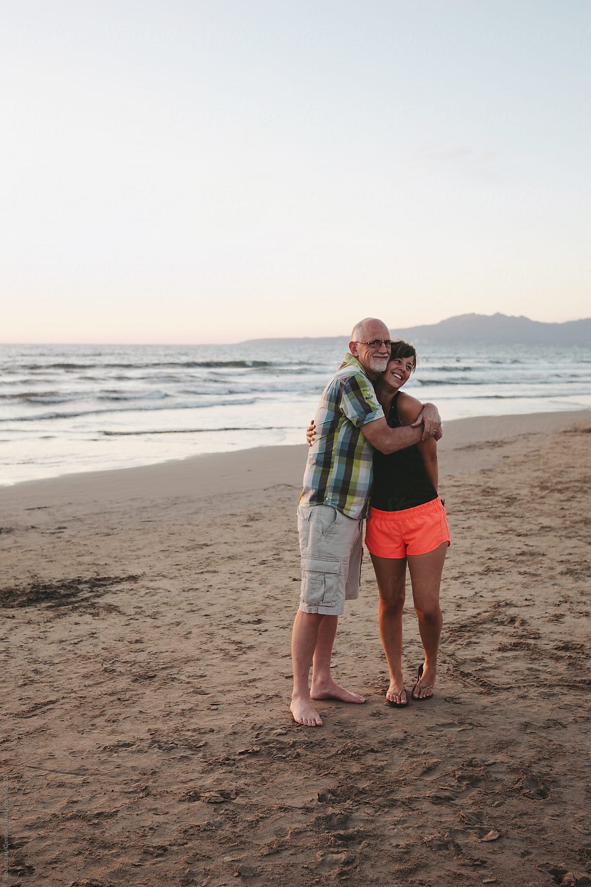 Smiling Middle Aged Man On The Beach At Sunset by Stocksy Contributor Rob  And Julia Campbell - Stocksy