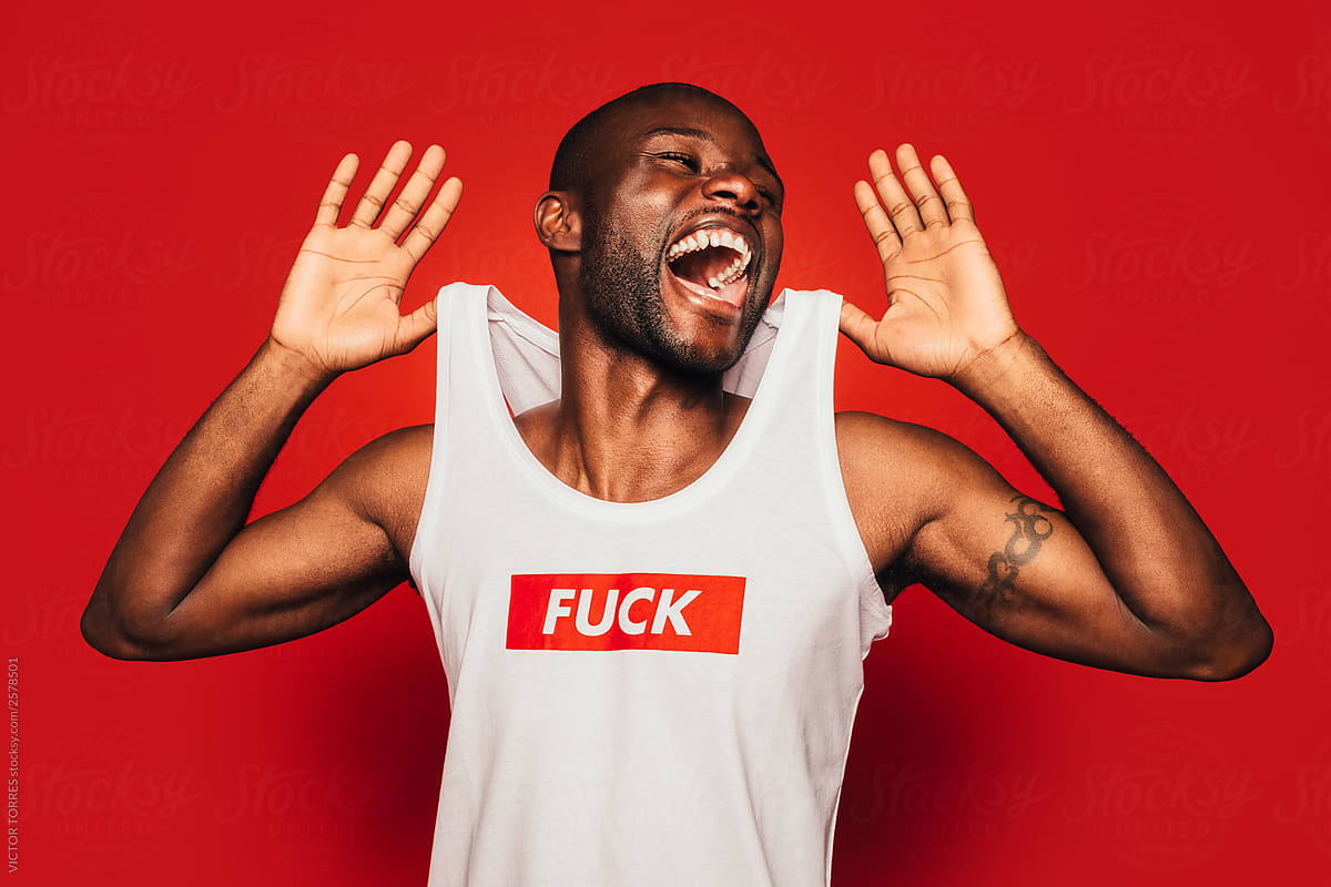Portrait of excited black man wearing a compromising t-shirt laughing away