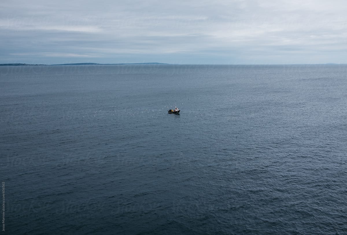 Small Boat In Ocean Water Off Coast Of Ireland by Stocksy Contributor  Jesse Morrow - Stocksy