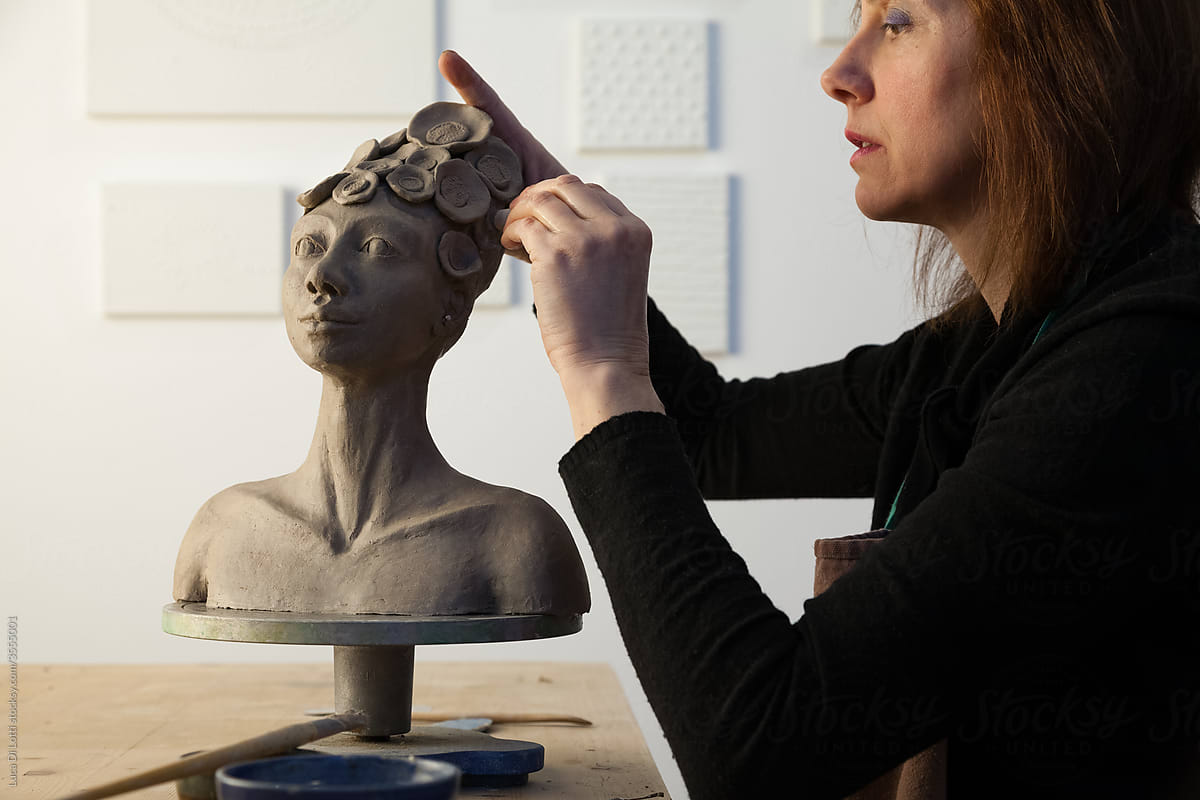 artist working on details of a clay statue