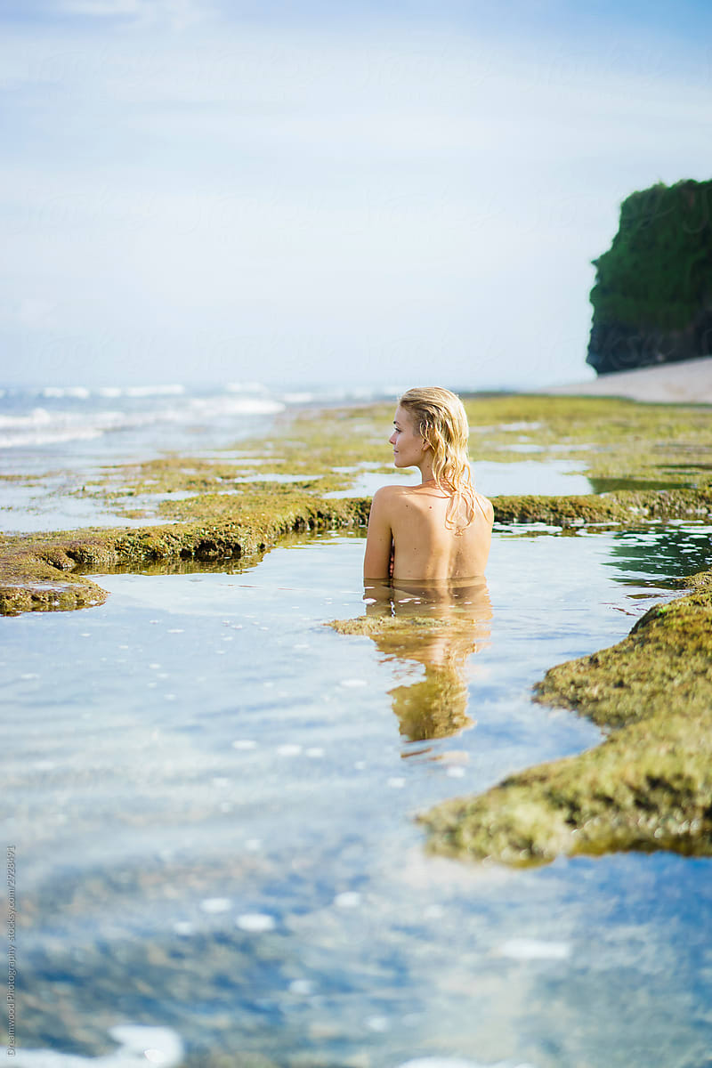 Blonde lady in swimsuit standing in deep pond