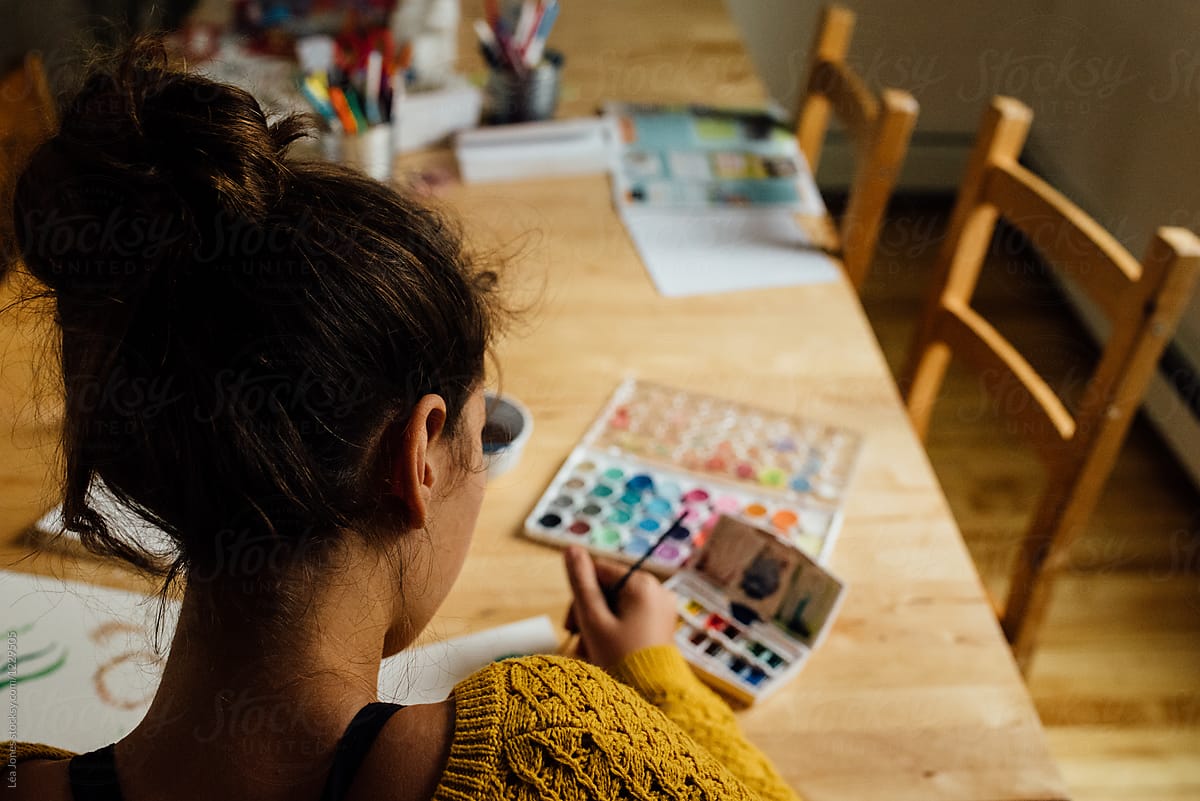 young woman painting cards with watercolours