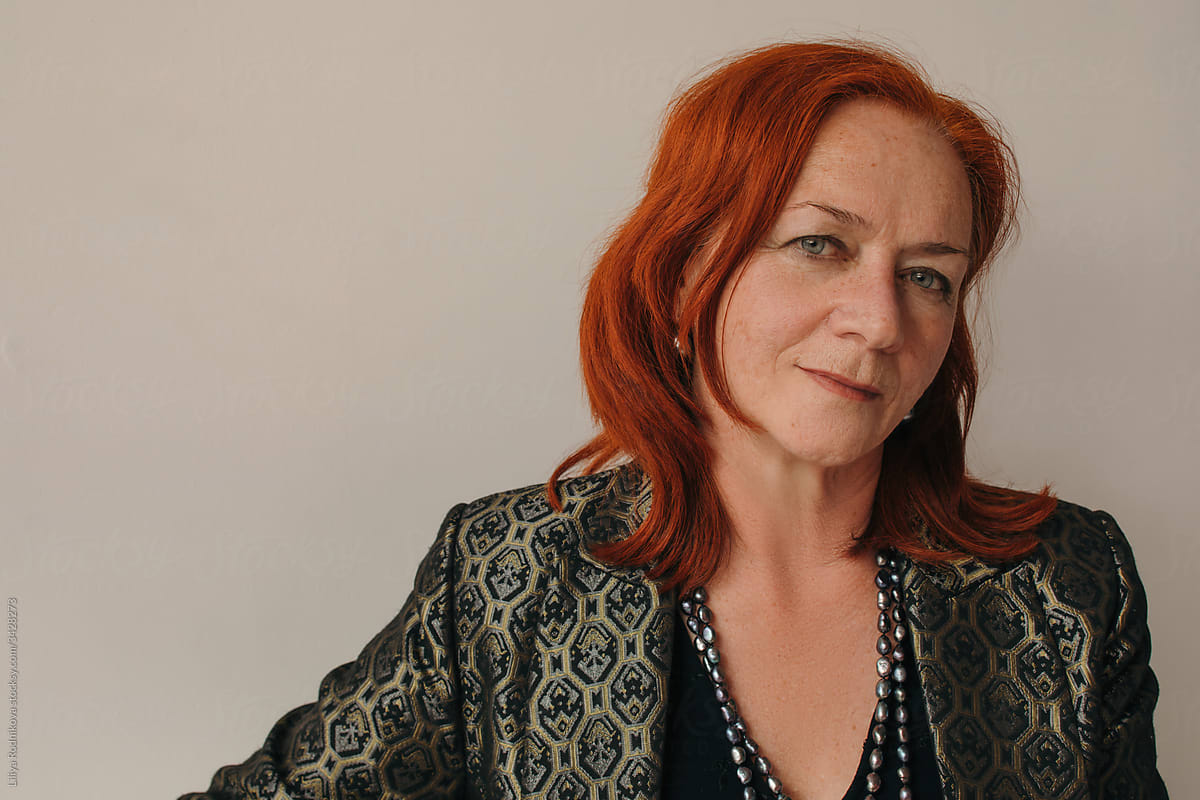 Headshot portrait of mature redhead woman