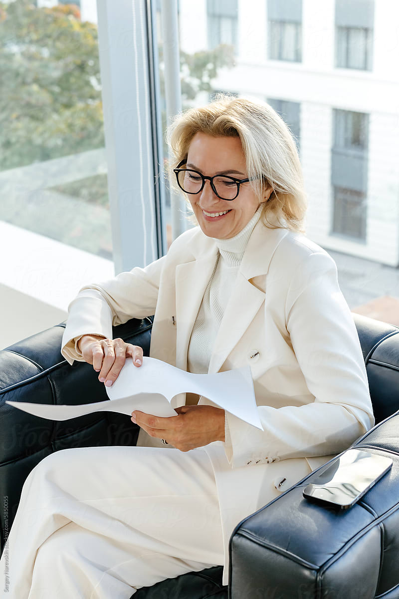Businesswoman with smile flipping through papers