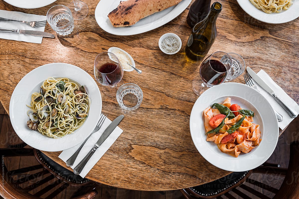 Bowls of fresh vegetarian pasta on restaurant wooden table
