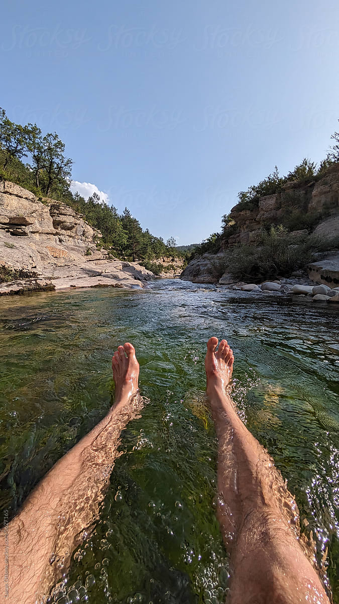 UGC POV photo of the legs of a man bathing in a river