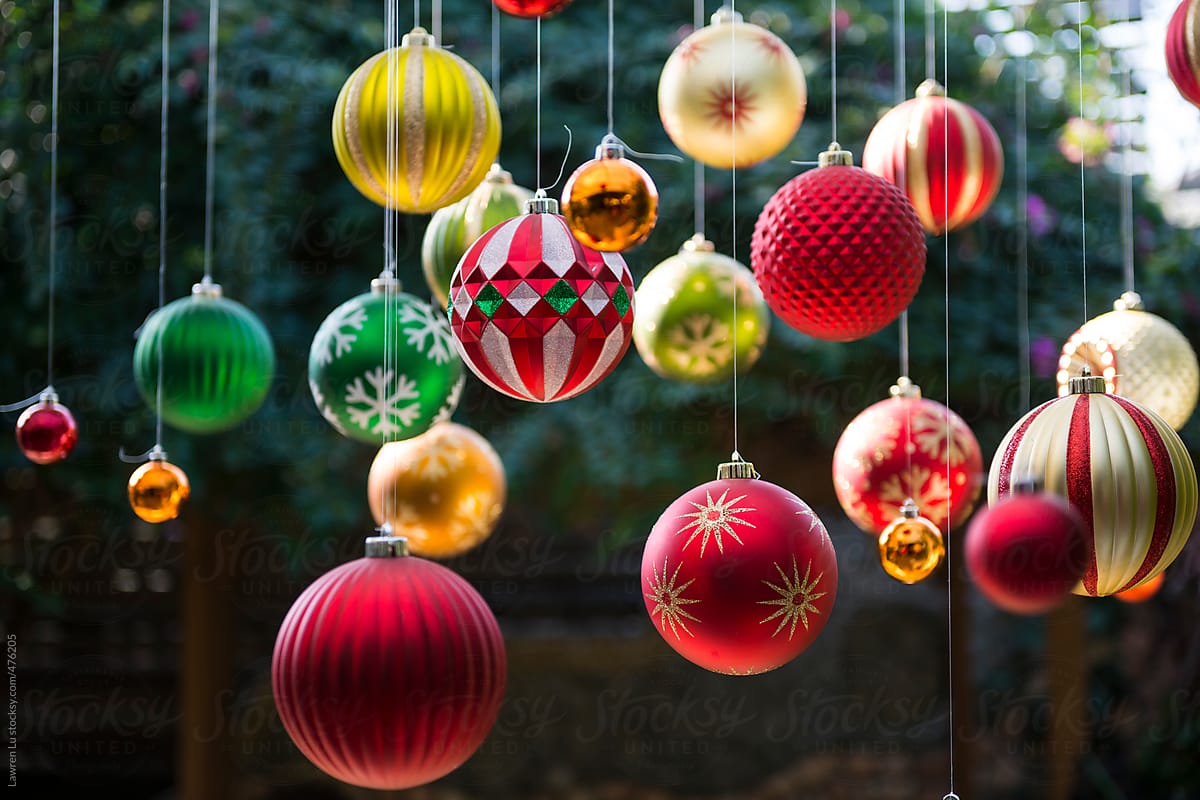Many colorful Christmas balls hanging in the garden with sunlight