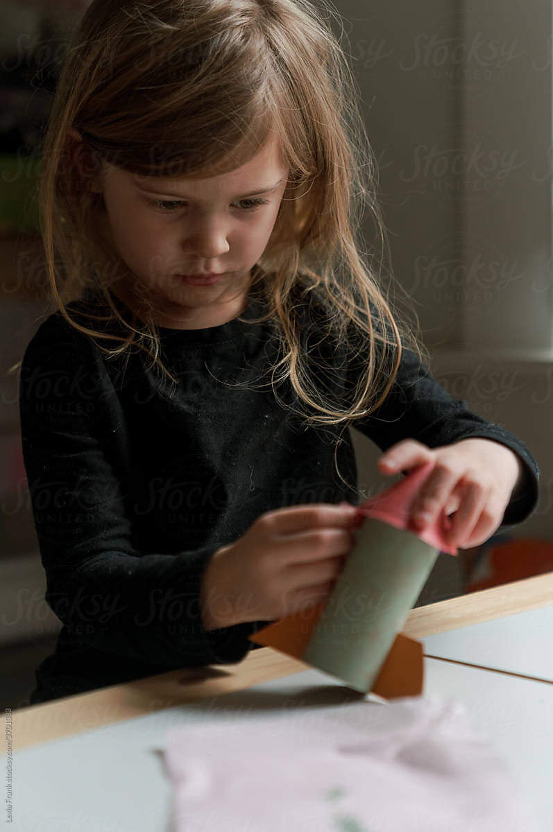 focused young girl makes a rocket ship at home