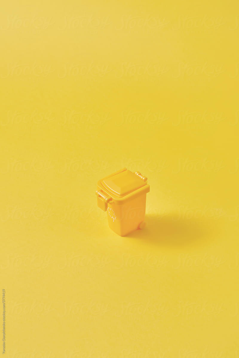 Small closed yellow trash can