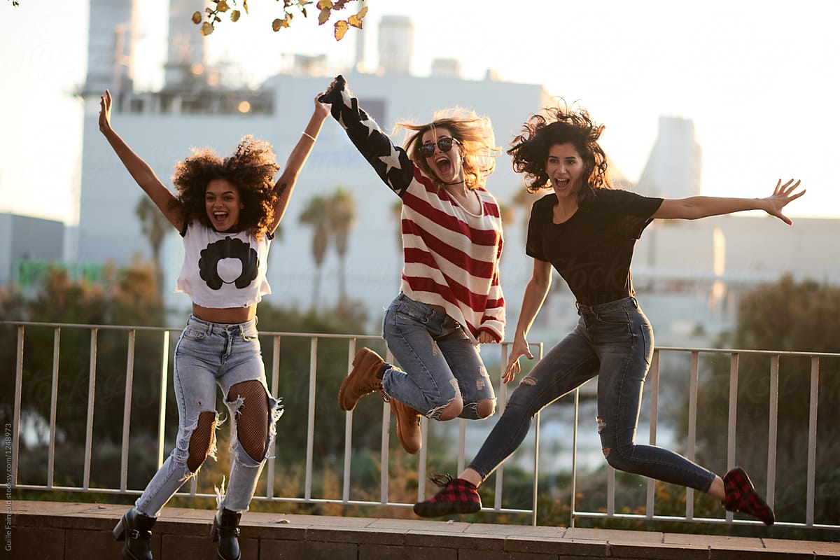 Cheerful Girlfriends Jumping Against City Buildings Del Colaborador De Stocksy Guille 