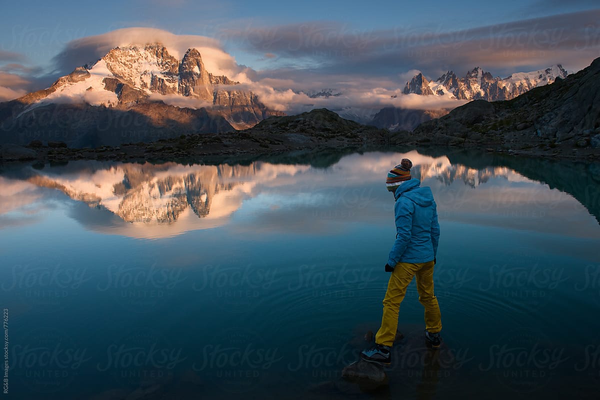 Woman standing on rocks at sunset, Lake Blanc, Alps