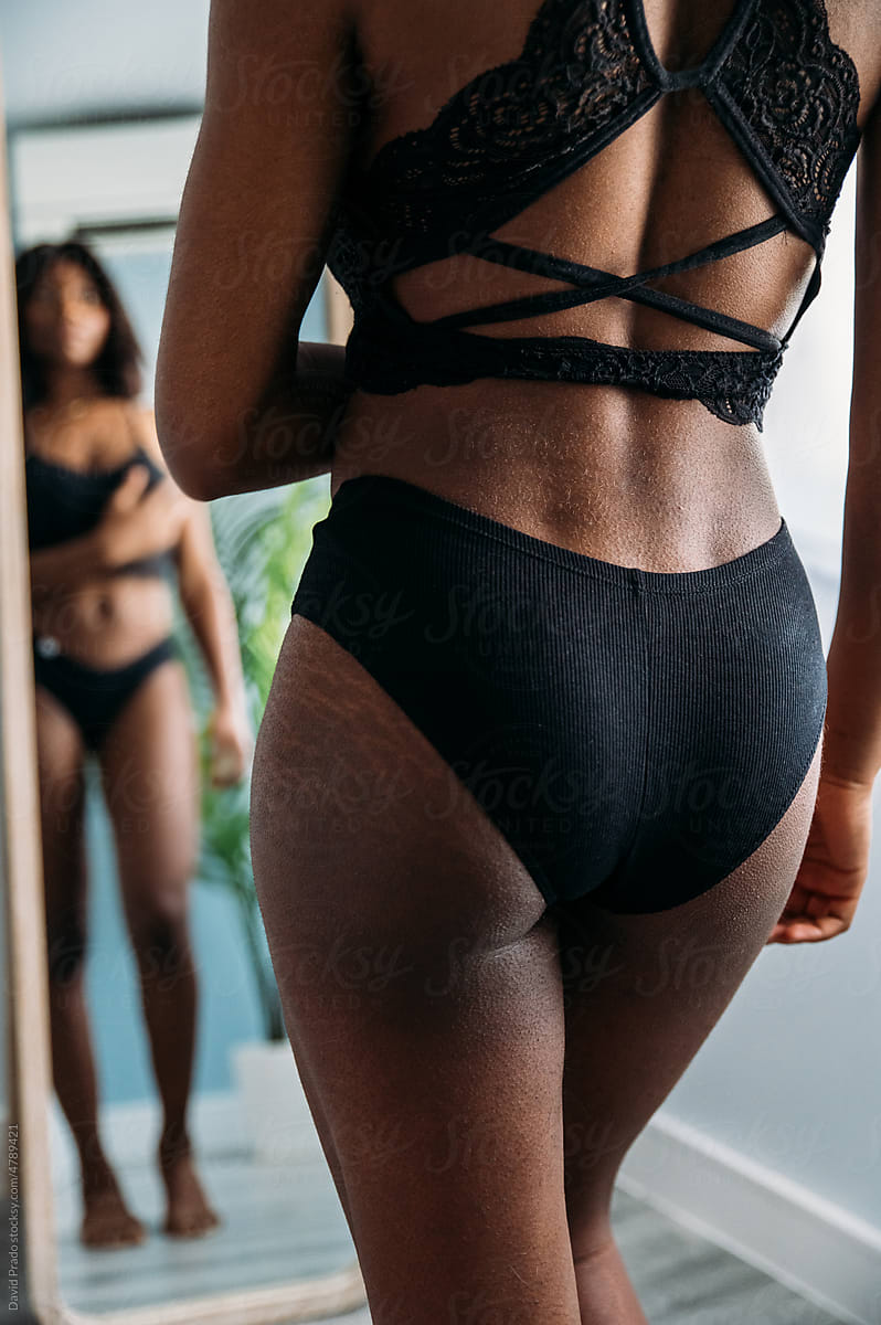 Unrecognizable Black Woman In Underwear Standing Near Mirror by Stocksy  Contributor David Prado - Stocksy
