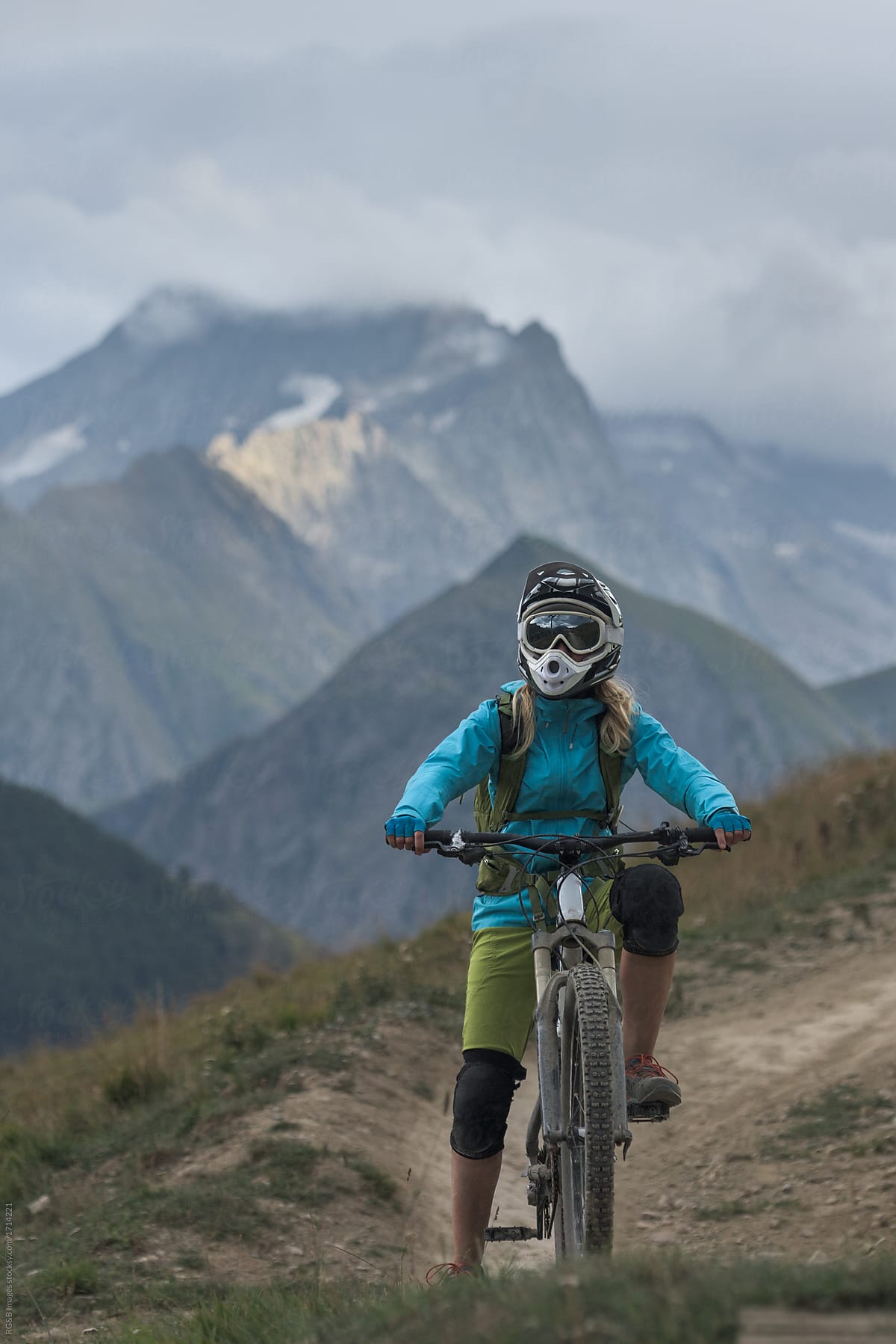 Woman with mountain bike riding on backcountry route in mountains