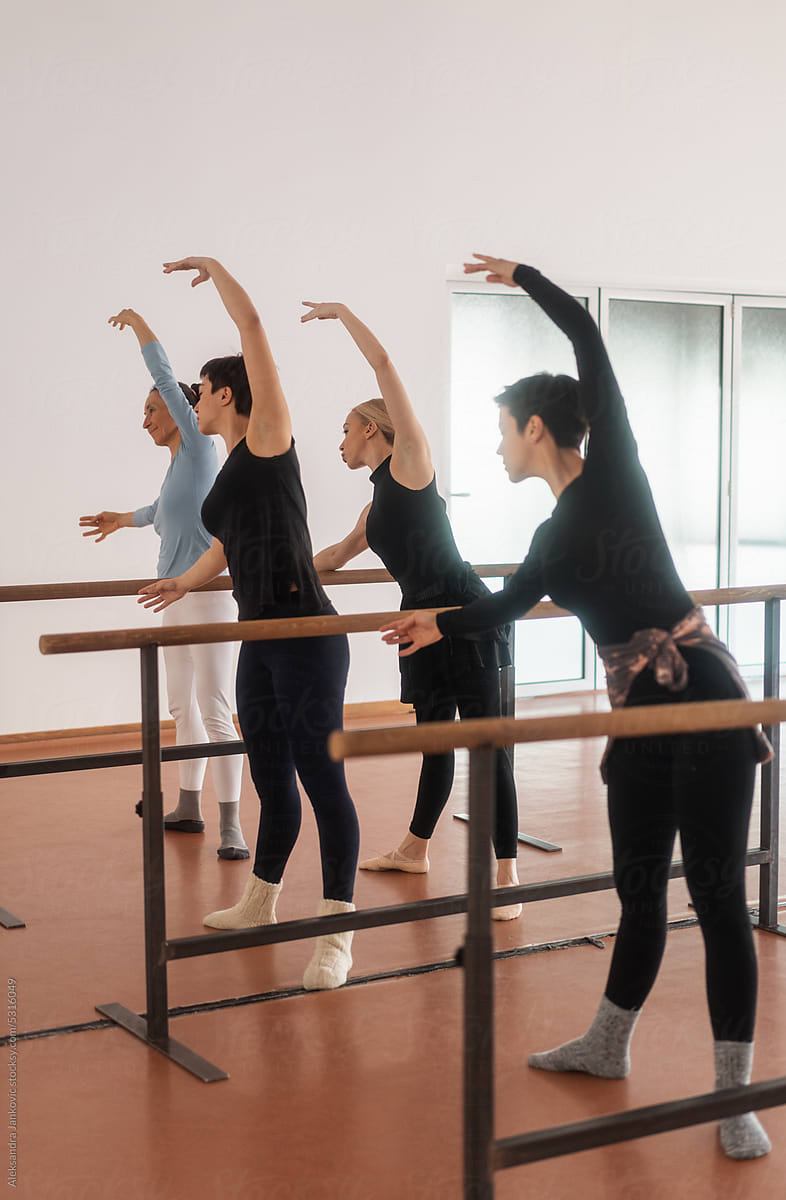 Group Of Women Practicing A Ballet Routine On The Bars