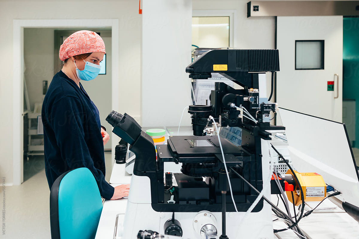 Female laboratory worker using microscope in lab