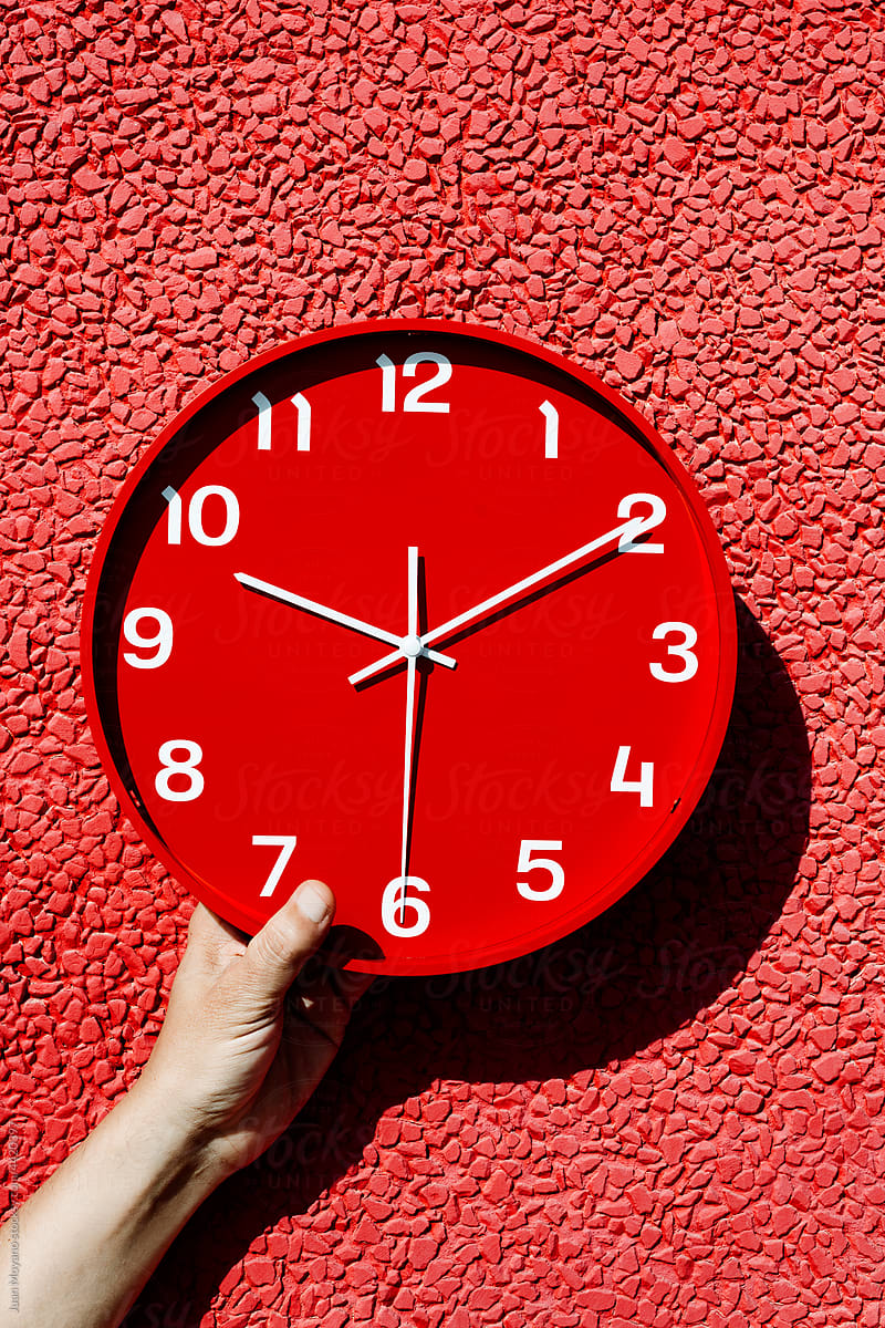 man with a red clock in his hand