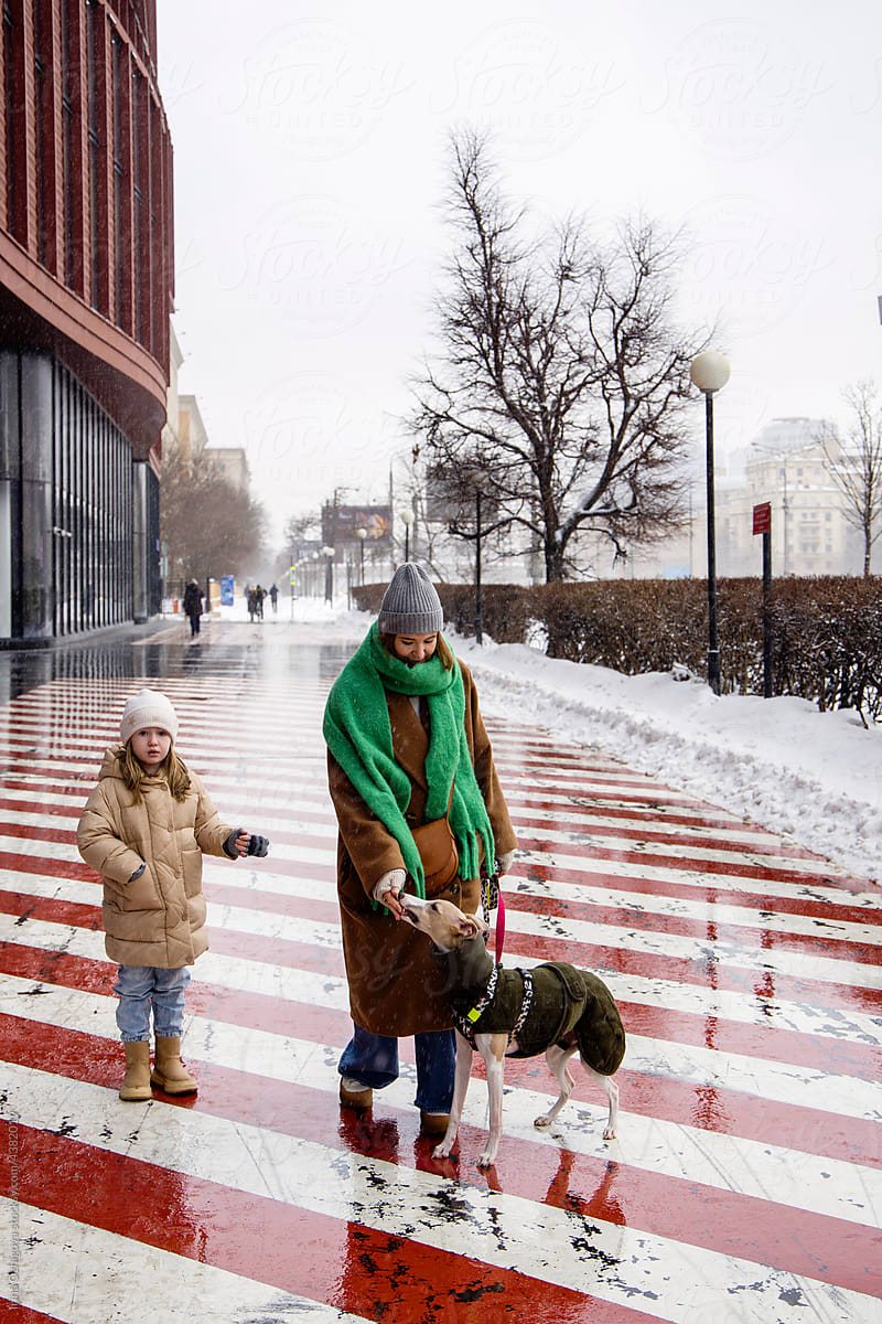 Mother and daughter walking with dog in winter