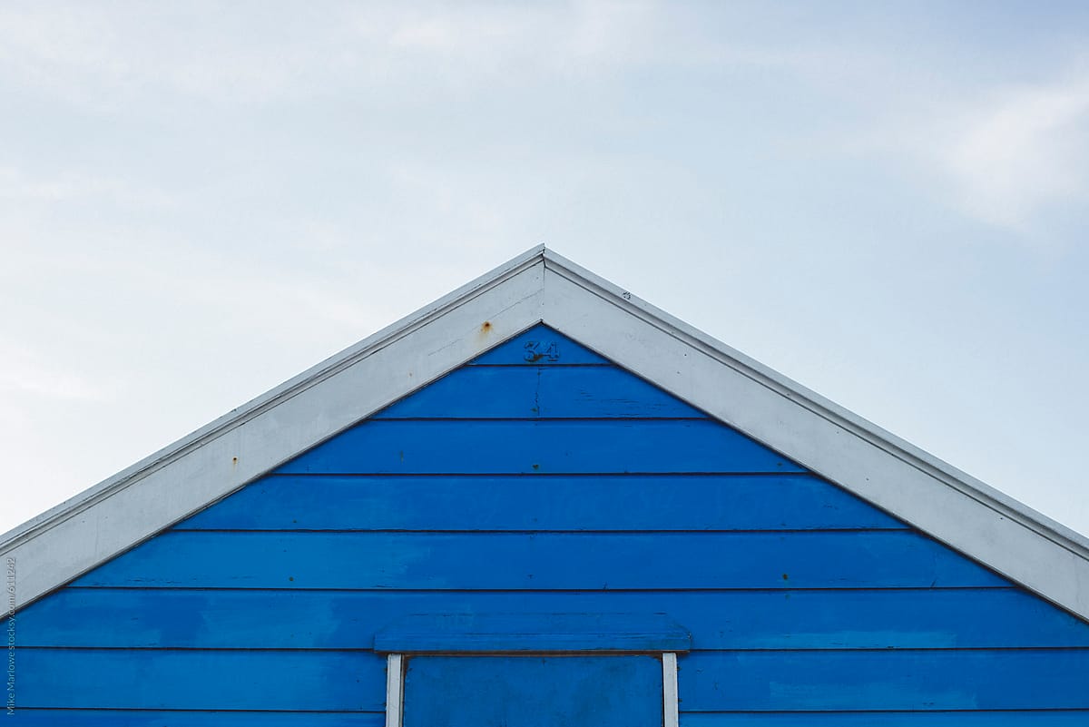 Apex of a wooden house against the sky with blue boards