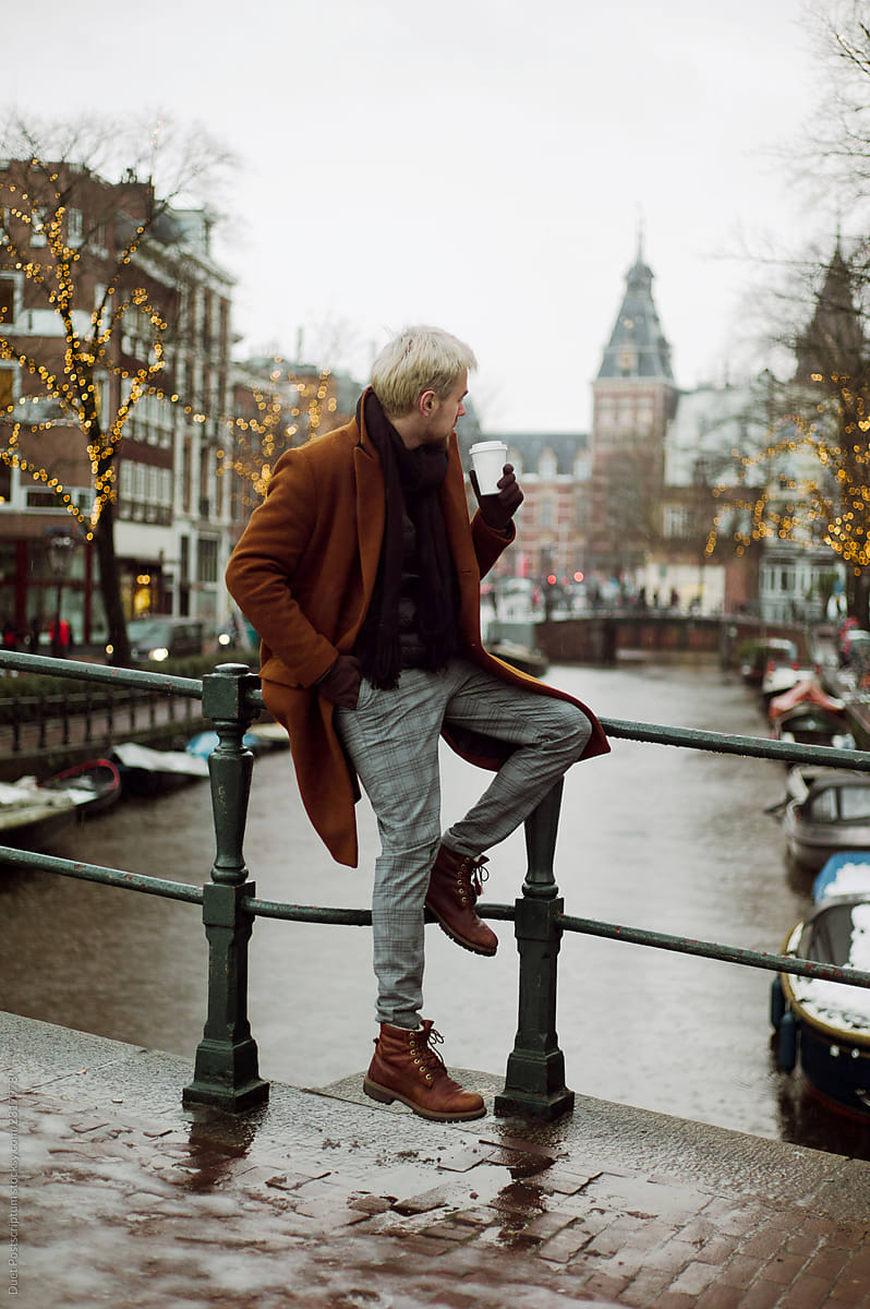 Man with coffee on bridge in winter time