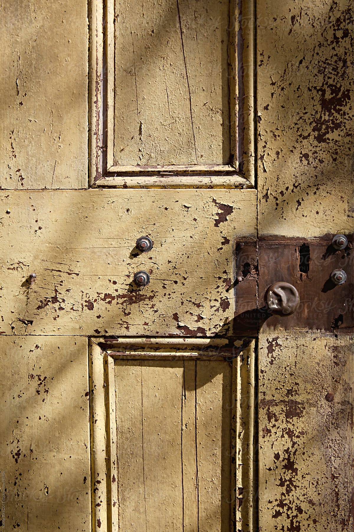 close up of old weathered door, handle and lock