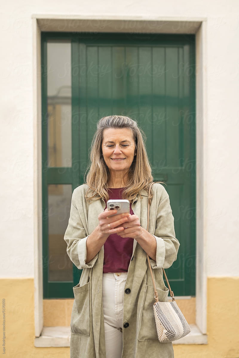 mature woman with mobile phone outdoors