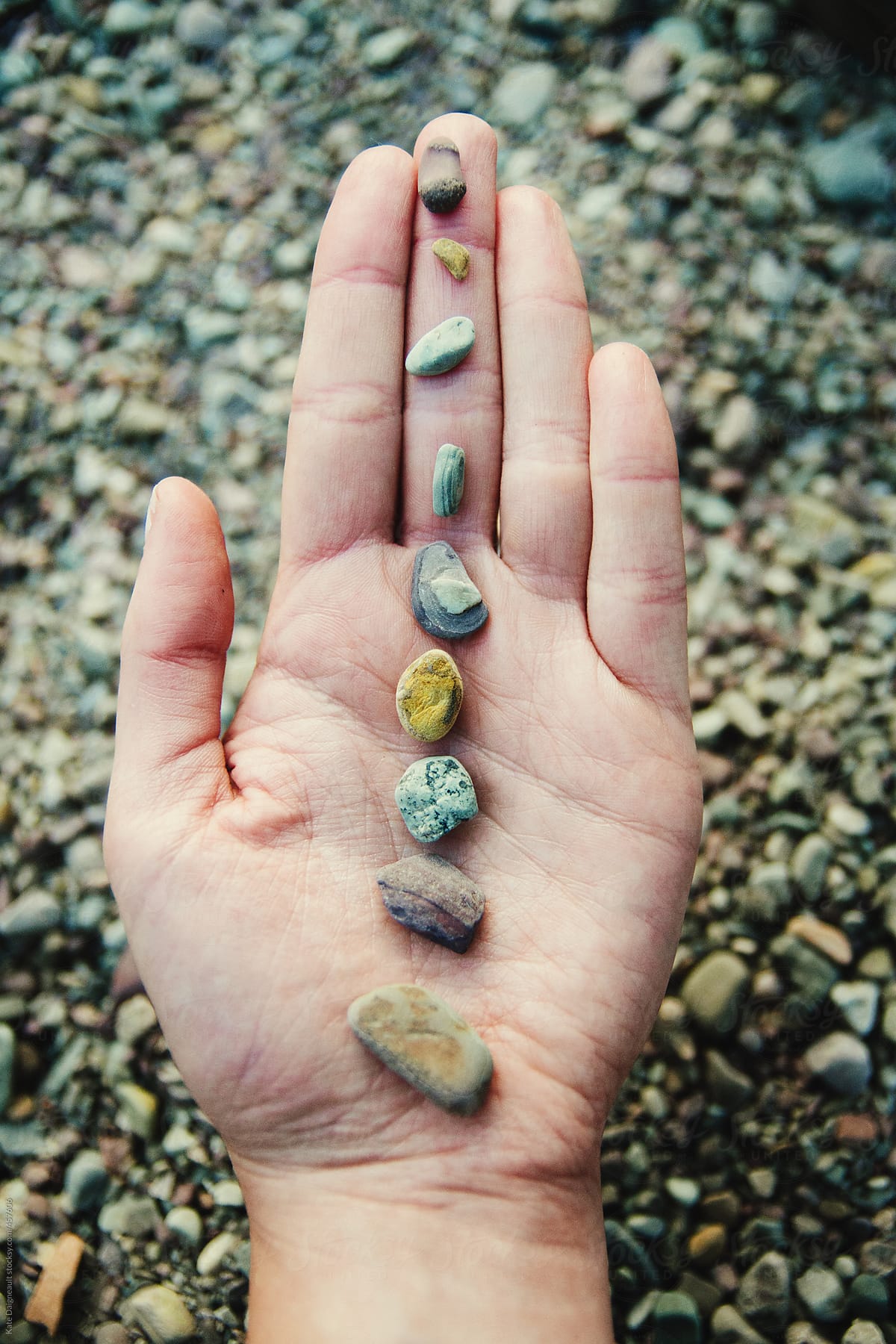 A row of colorful stones carefully aligned on a hand