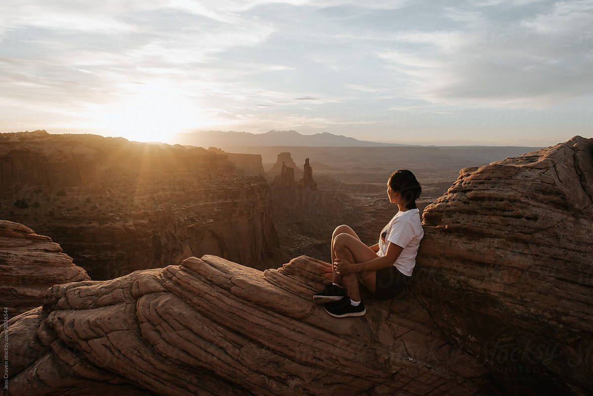 Young female hiker watching sunset in Utah